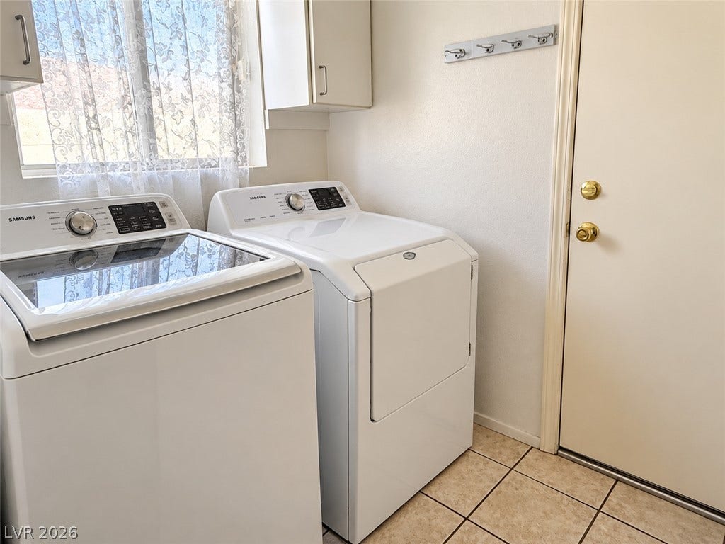 3925 Lilac Haze Street, Las Vegas, NV 89147 Practical laundry setup with durable tile flooring and overhead cabinetry.