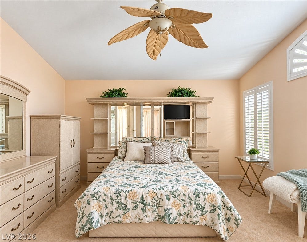3925 Lilac Haze Street, Las Vegas, NV 89147 A spacious bedroom features neutral carpeting and plantation shutters on the windows.