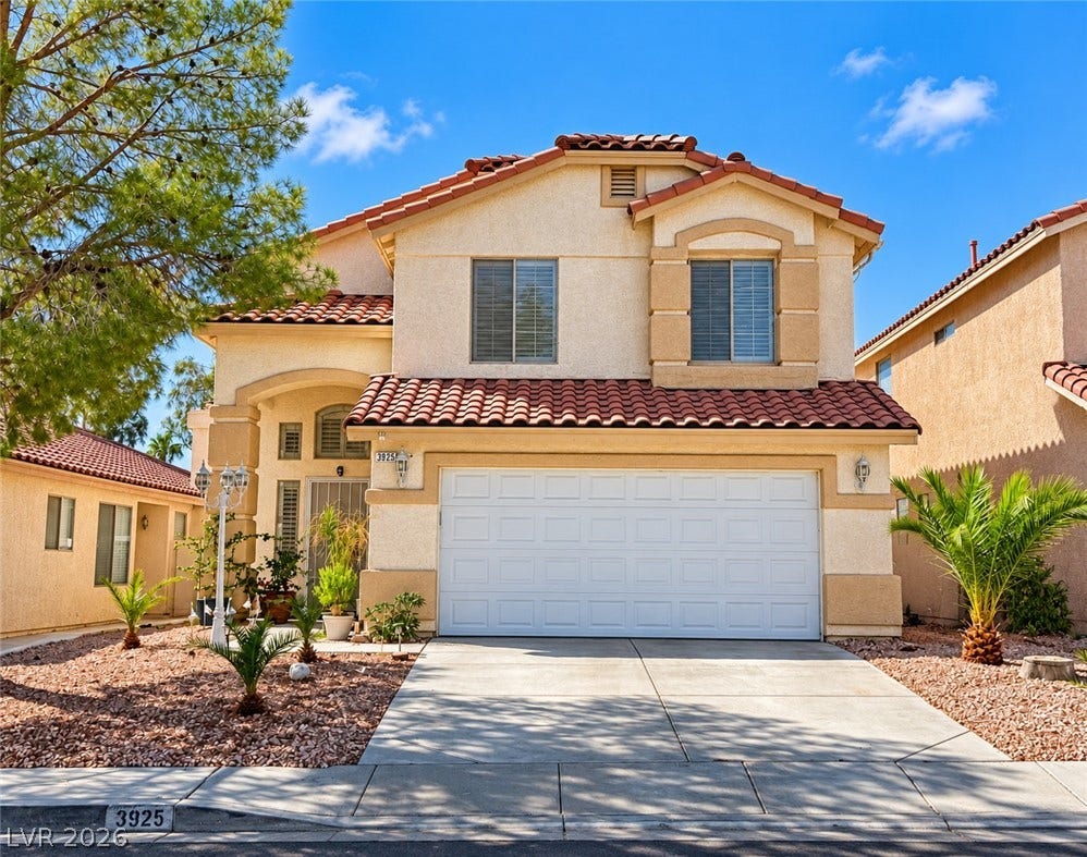 3925 Lilac Haze Street, Las Vegas, NV 89147 A classic two-story facade with a tile roof and integrated garage coordinates with desert landscaping.