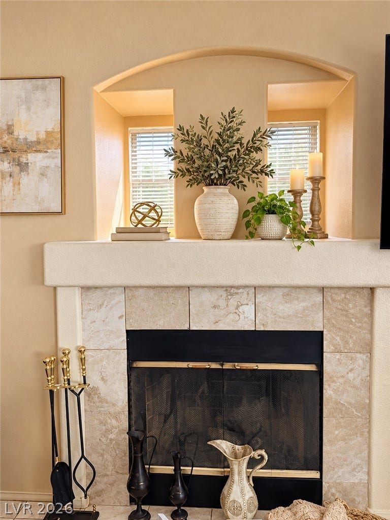 3925 Lilac Haze Street, Las Vegas, NV 89147 An elegant tile fireplace anchors the living room beneath a custom arched display alcove.