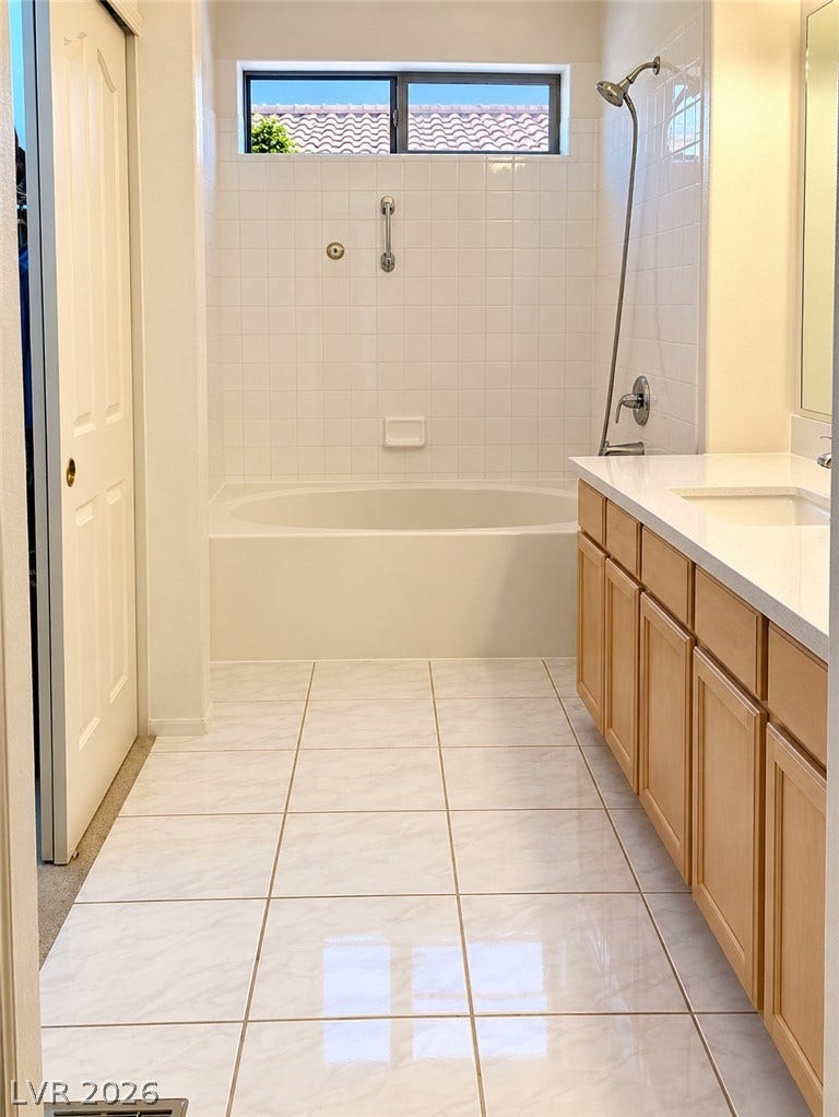 3925 Lilac Haze Street, Las Vegas, NV 89147 Tiled flooring and a separate soaking tub create a functional bathroom layout.