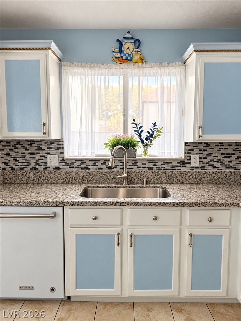 3925 Lilac Haze Street, Las Vegas, NV 89147 A sunny window illuminates the stone countertops and stainless steel sink in this inviting kitchen.
