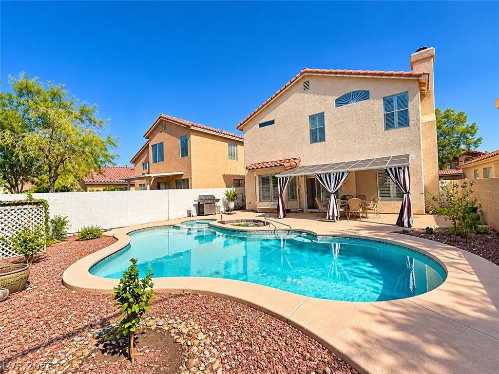 3925 Lilac Haze Street, Las Vegas, NV 89147 An inviting backyard oasis features a curved swimming pool, covered patio, and low-maintenance landscaping.