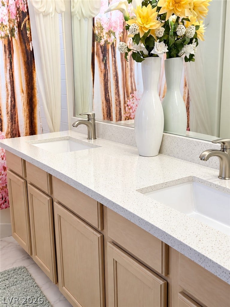 3925 Lilac Haze Street, Las Vegas, NV 89147 Double under-mount sinks rest within a speckled quartz countertop and a light wood vanity.