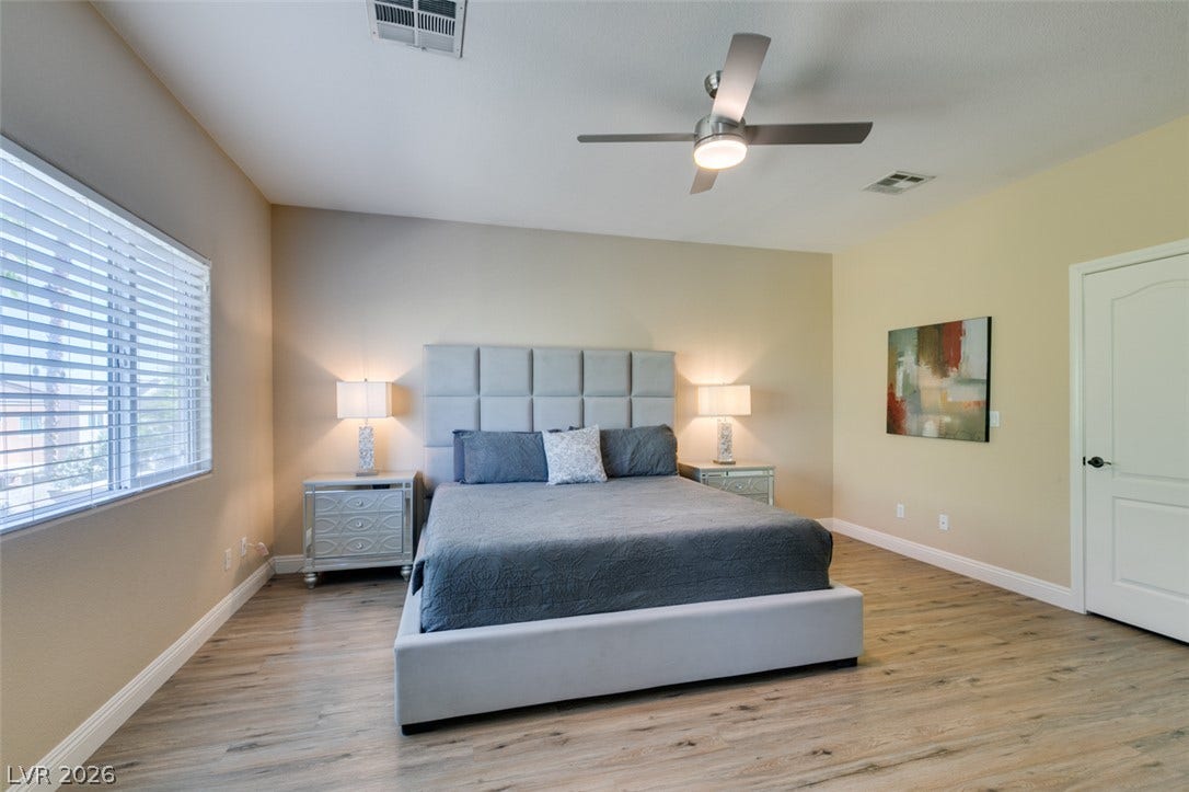 3166 E Eldorado Lane, Las Vegas, NV 89120 Warm wood-look flooring and generous natural light define this inviting, comfortable bedroom retreat.