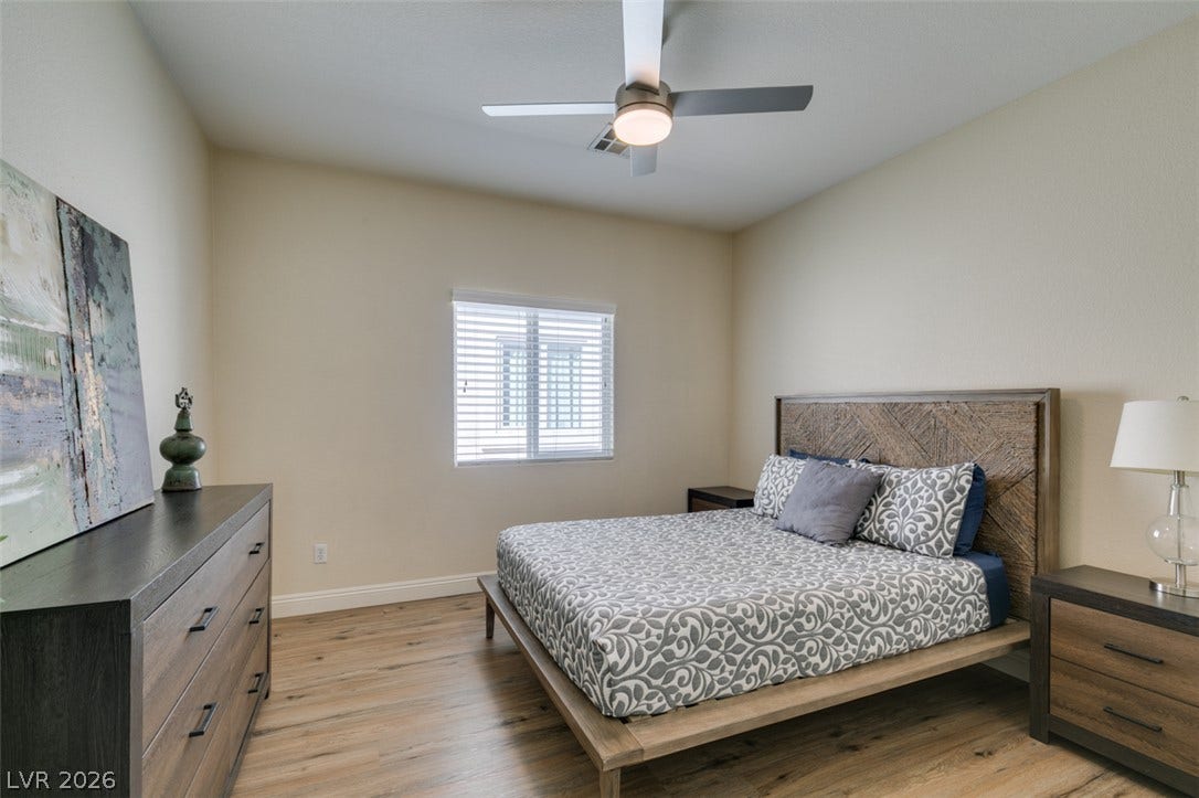3166 E Eldorado Lane, Las Vegas, NV 89120 Warm wood flooring and clean lines define this inviting bedroom space.