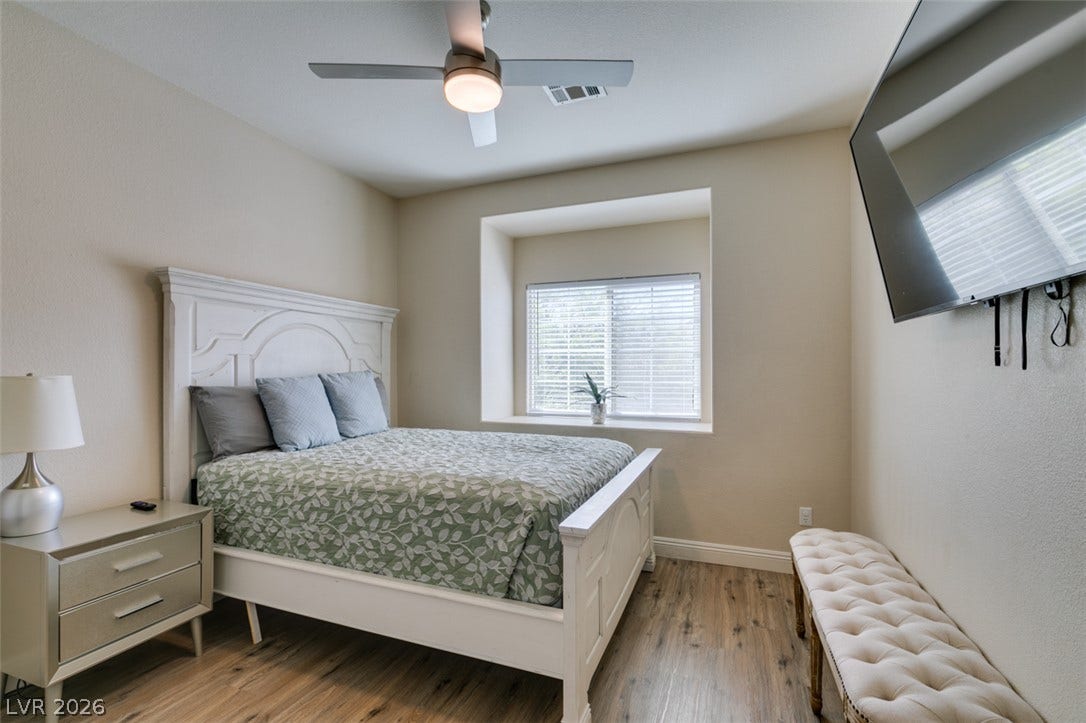 3166 E Eldorado Lane, Las Vegas, NV 89120 Warm wood flooring and a deep-set picture window anchor this comfortable resting space.
