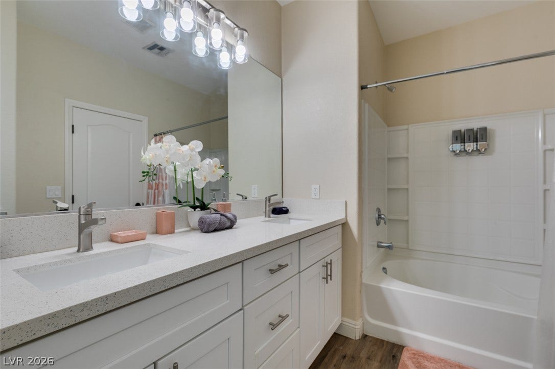 3166 E Eldorado Lane, Las Vegas, NV 89120 A spacious double vanity and a built-in tub with tile surrounds complete this bathroom.