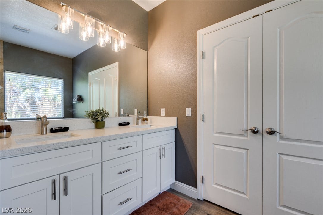 3166 E Eldorado Lane, Las Vegas, NV 89120 A spacious double vanity anchors this modern bathroom completed with clean cabinetry.