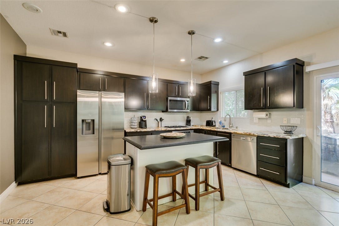 3166 E Eldorado Lane, Las Vegas, NV 89120 Dark cabinetry and light-colored tile flooring create elegant contrast in this modern culinary space.