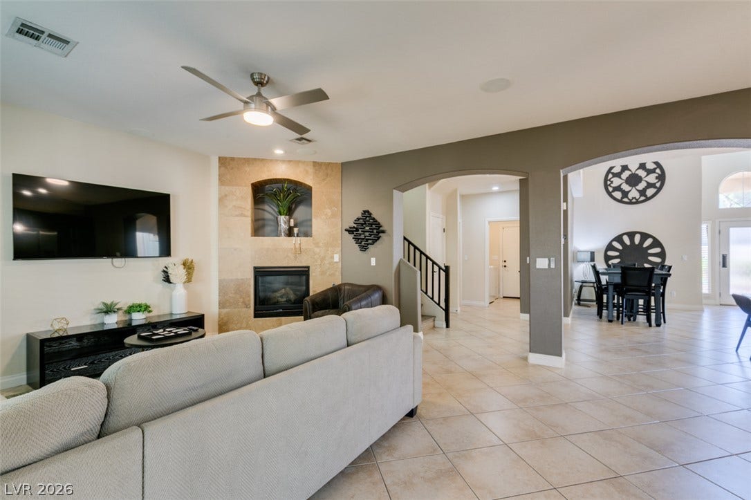 3166 E Eldorado Lane, Las Vegas, NV 89120 Tiled flooring and arched doorways define this comfortable, open living space with a fireplace.