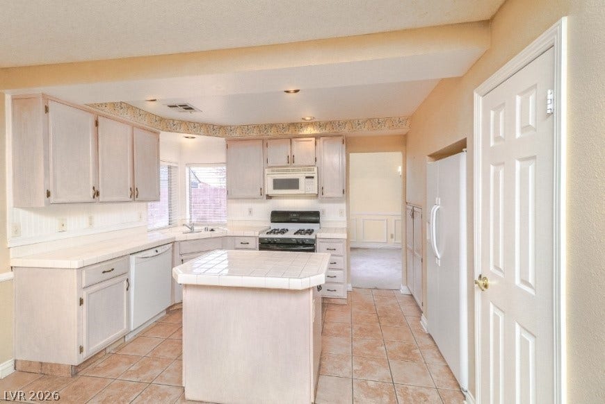 1429 Hawkwood Road, Henderson, NV 89014 Tiled flooring and matching countertops define this functional kitchen space complete with a central island.