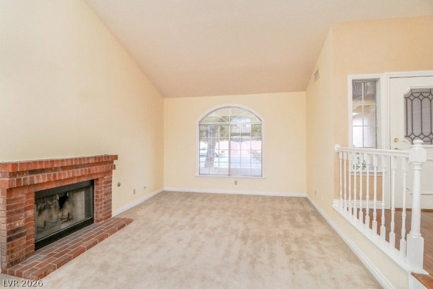 1429 Hawkwood Road, Henderson, NV 89014 Vaulted ceilings and a brick fireplace define this inviting living room.