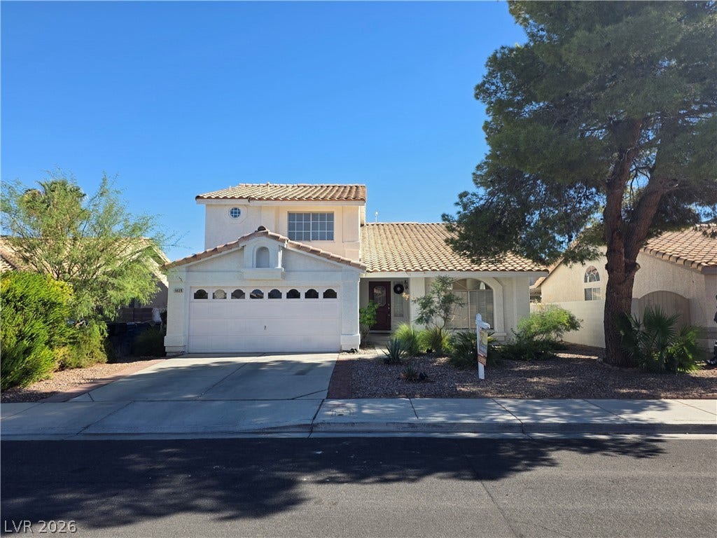 1429 Hawkwood Road, Henderson, NV 89014 Mediterranean-inspired architecture highlights this multi-level home featuring a tile roof and attached garage.