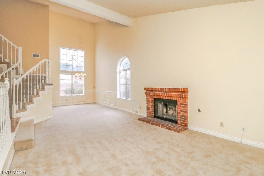 1429 Hawkwood Road, Henderson, NV 89014 Soaring vaulted ceilings and a classic brick fireplace anchor this light-filled living area.