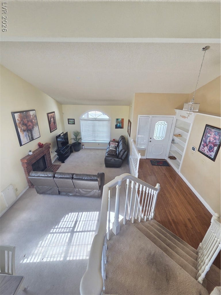 1429 Hawkwood Road, Henderson, NV 89014 Gleaming hardwood floors and a brick fireplace highlight this inviting, multi-level living area.