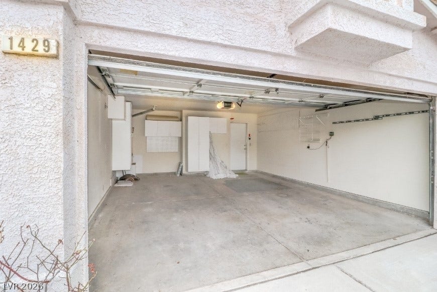1429 Hawkwood Road, Henderson, NV 89014 A spacious garage features durable concrete flooring, built-in storage cabinets, and direct home access.
