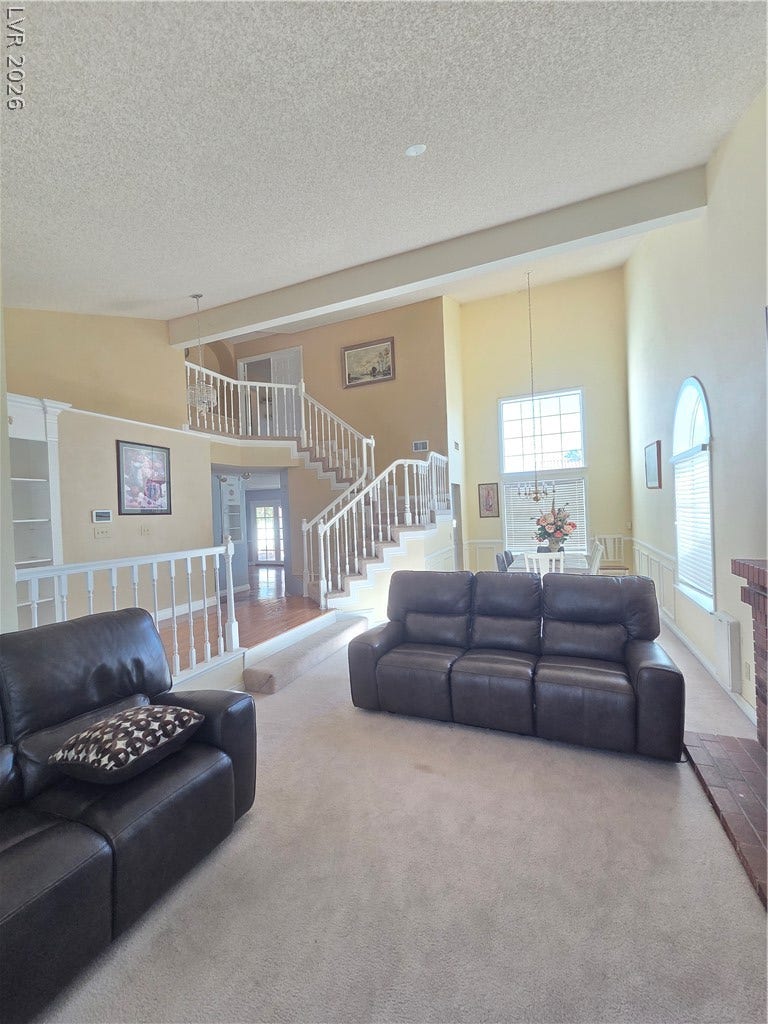 1429 Hawkwood Road, Henderson, NV 89014 A spacious multi-level layout highlights comfortable carpeted living space beneath vaulted ceilings.