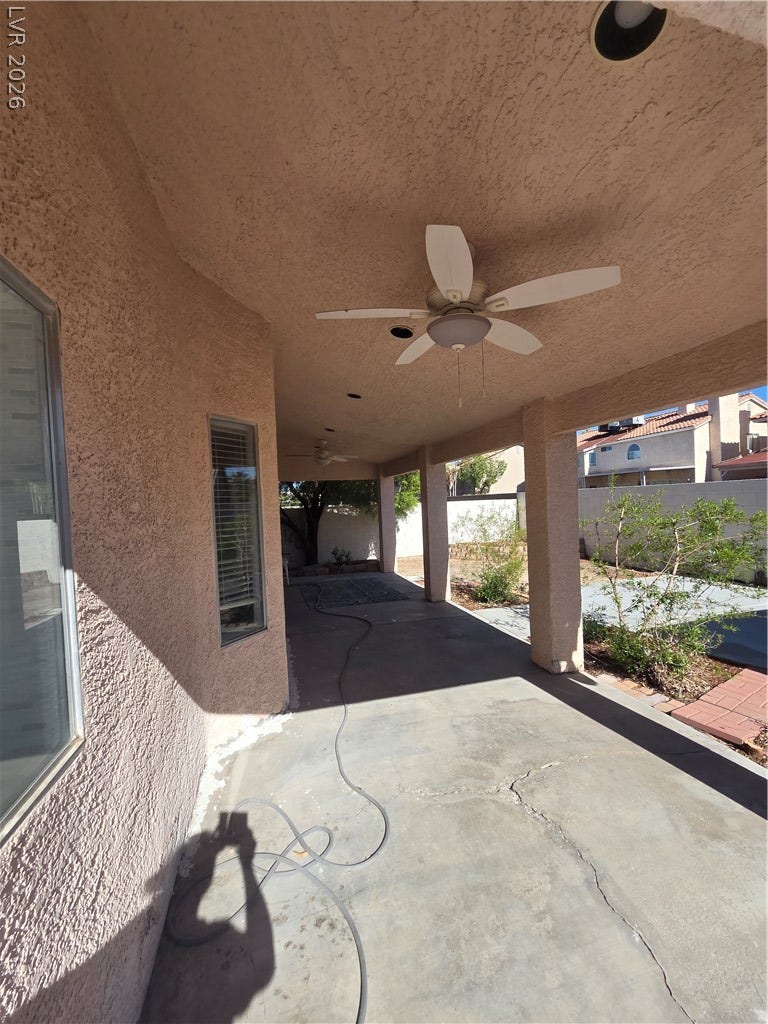 1429 Hawkwood Road, Henderson, NV 89014 A covered concrete patio extends alongside the textured exterior wall under protective shelter.