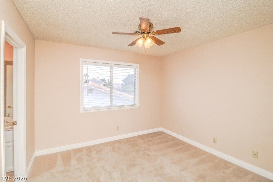 1429 Hawkwood Road, Henderson, NV 89014 Soft carpeting pairs with a wide window overlooking the neighborhood in this cozy bedroom.