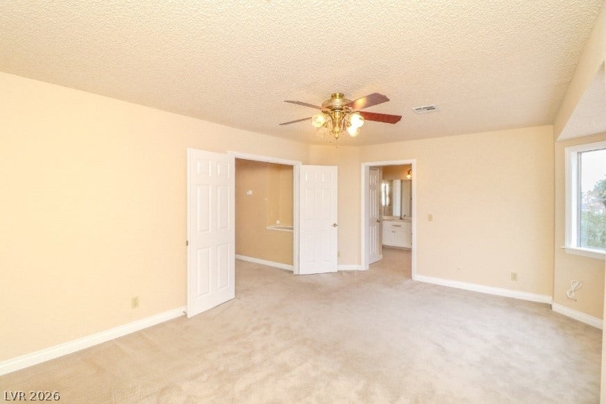 1429 Hawkwood Road, Henderson, NV 89014 Plentiful natural light streams through the large window in this carpeted primary bedroom.