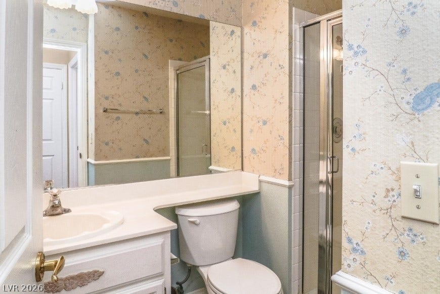 1429 Hawkwood Road, Henderson, NV 89014 Classic wallpaper pattern and wainscoting paneling define this charming bathroom layout.