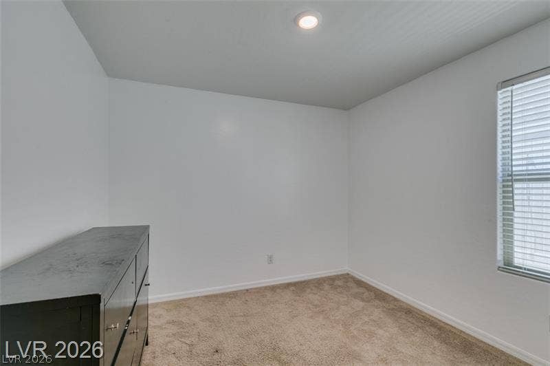 Recessed lighting and soft carpeting create a cozy atmosphere in this versatile bedroom.