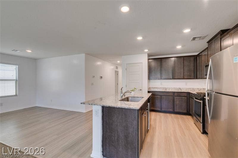 Granite countertops and dark cabinetry define a modern kitchen opening directly to the living area.