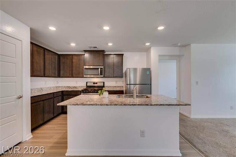 Granite countertops and dark cabinetry create a modern culinary space anchored by a central island.