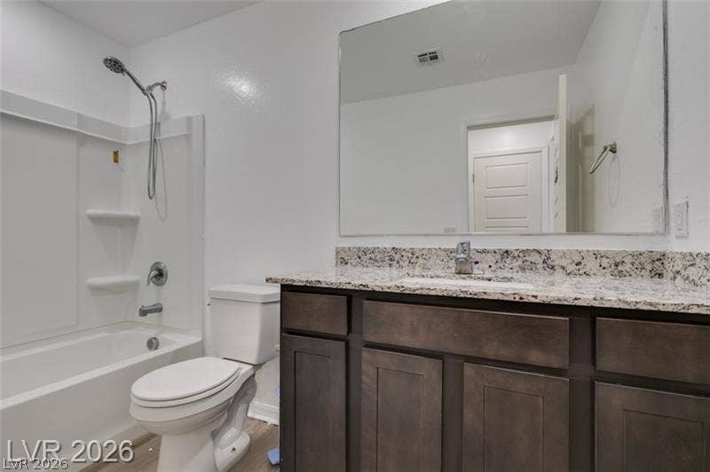 Polished granite countertops complement dark wood cabinetry in this refreshed bathroom.