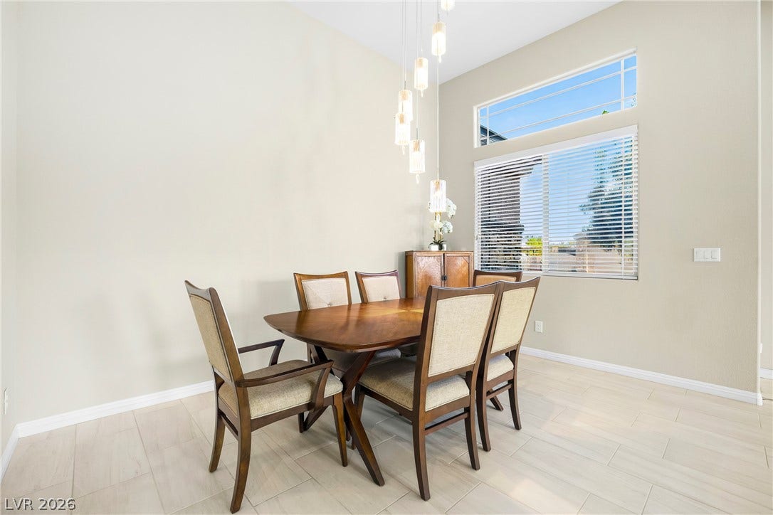 7230 Fresh Harvest Avenue, Las Vegas, NV 89131 Natural light floods this inviting dining space, featuring high ceilings and elegant tile flooring.