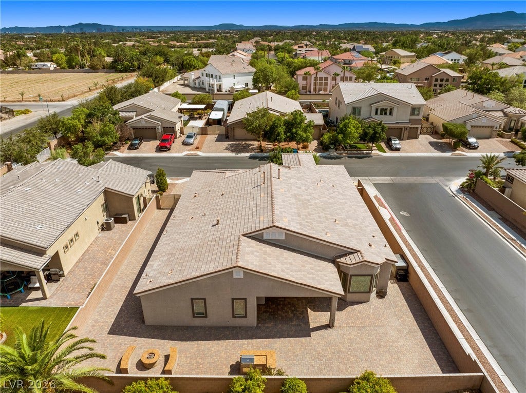 7230 Fresh Harvest Avenue, Las Vegas, NV 89131 An aerial perspective reveals a well-maintained neighborhood with a diverse collection of homes, nestled amidst mature trees and a vast landscape.