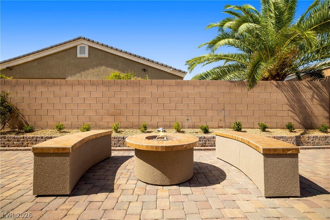 7230 Fresh Harvest Avenue, Las Vegas, NV 89131 An inviting backyard oasis offers a built-in fire pit with curved, block seating and brick pavers underfoot.