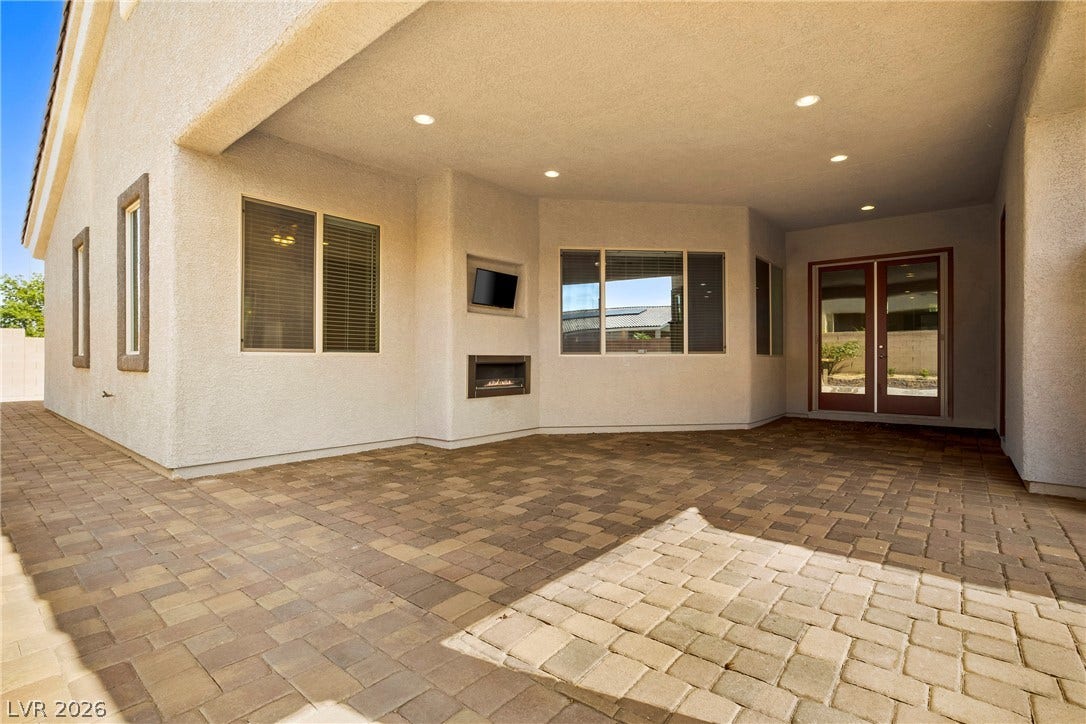 7230 Fresh Harvest Avenue, Las Vegas, NV 89131 An inviting covered patio features a built-in fireplace and ample paved space for outdoor living.