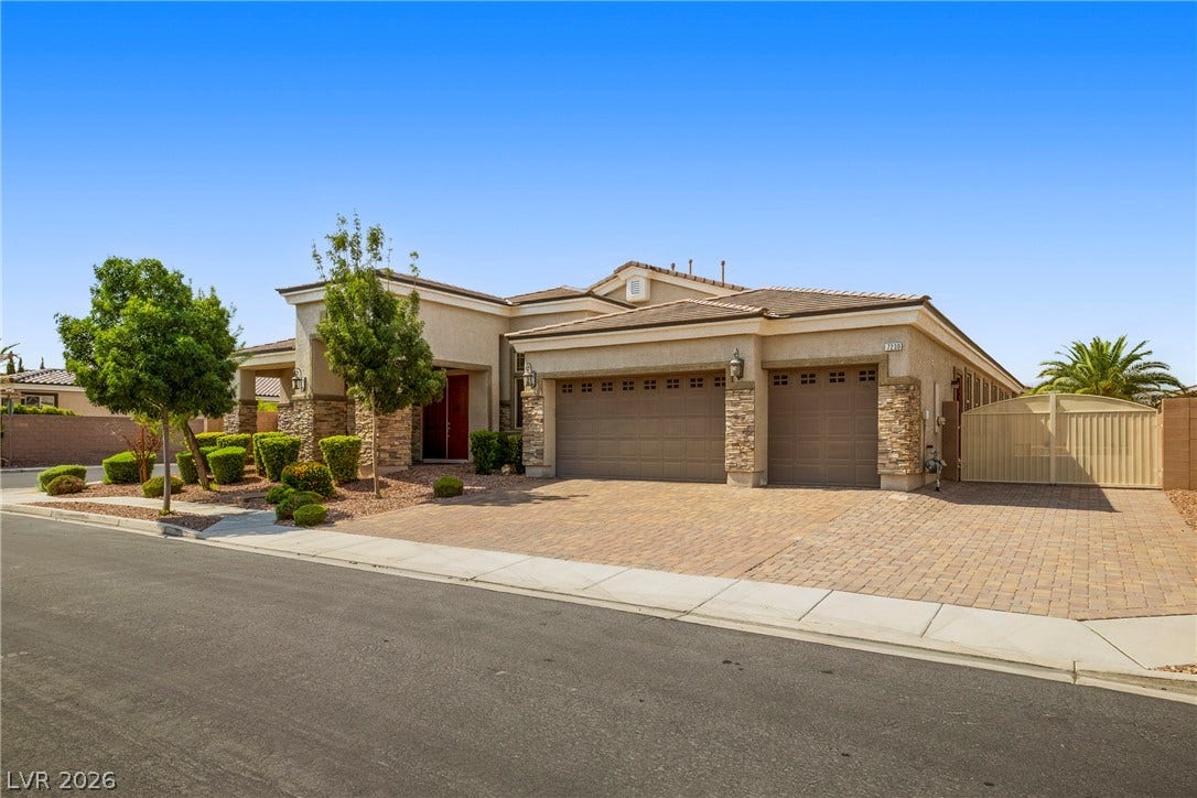 7230 Fresh Harvest Avenue, Las Vegas, NV 89131 A graceful home with a paver driveway, stone accents, and mature landscaping for optimal curb appeal.