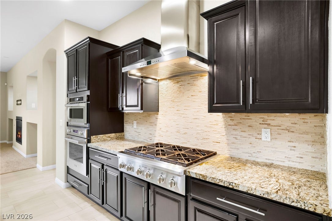 7230 Fresh Harvest Avenue, Las Vegas, NV 89131 Updated Kitchen with Built-in Monogram Microwave, Oven and Cook-top and Range Hood with fan and ample lighting.