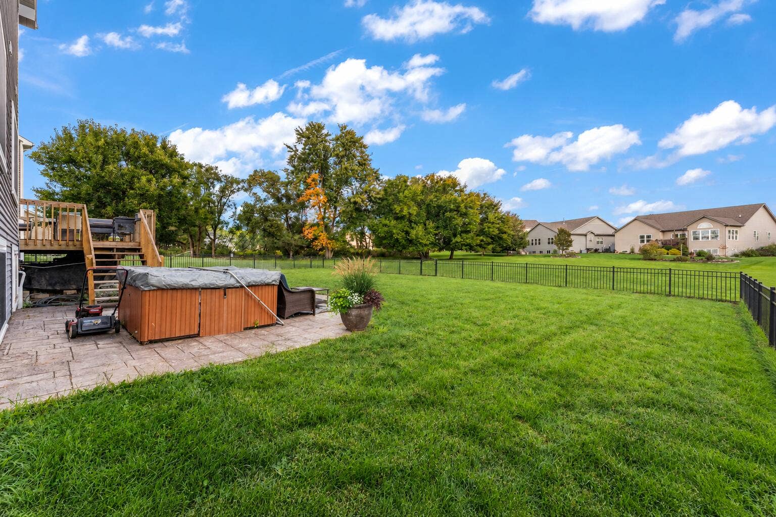 Sunny Suburban Backyard with Hot Tub and