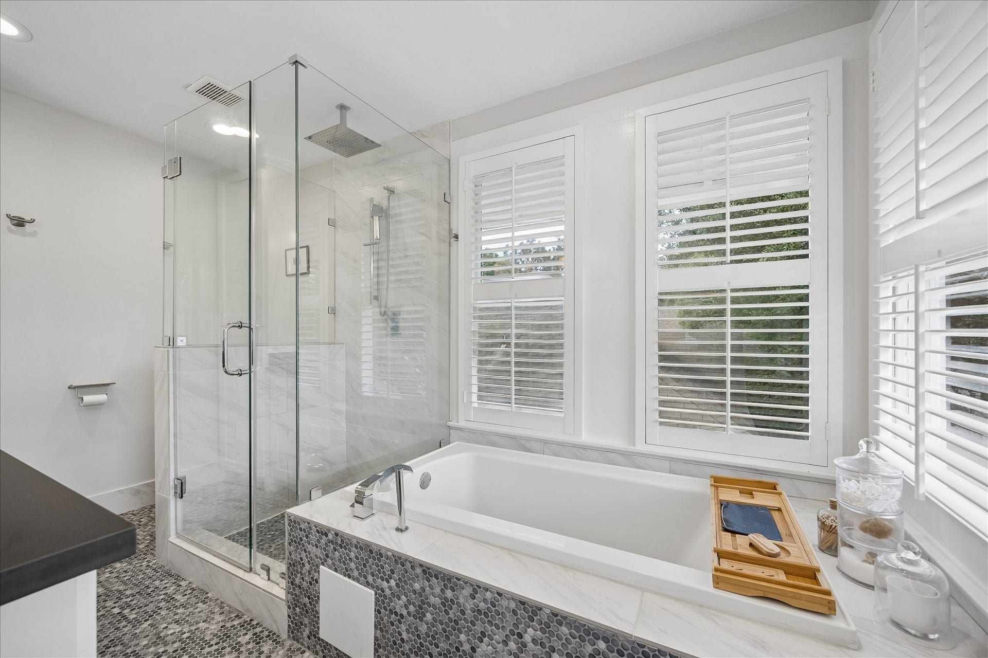 1221 Columbia Street, Houston, TX 77008 The primary bath is outfitted with a luxurious soaking tub and separate frameless glass shower. The room has incredible natural light, and again the plantation shutters provide for closing the lower sections for privacy.