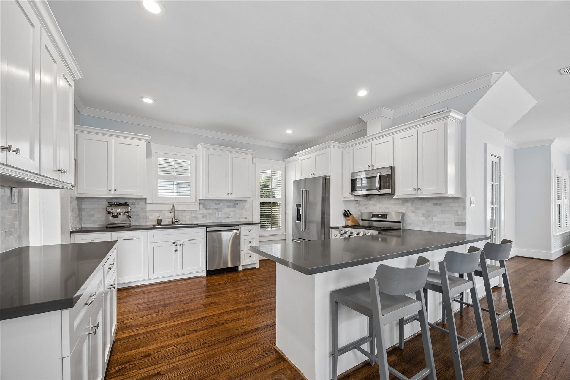 1221 Columbia Street, Houston, TX 77008 Quartz countertops and a neutral backsplash are timeless. Just beyond the refrigerator are the pantry cabinets.