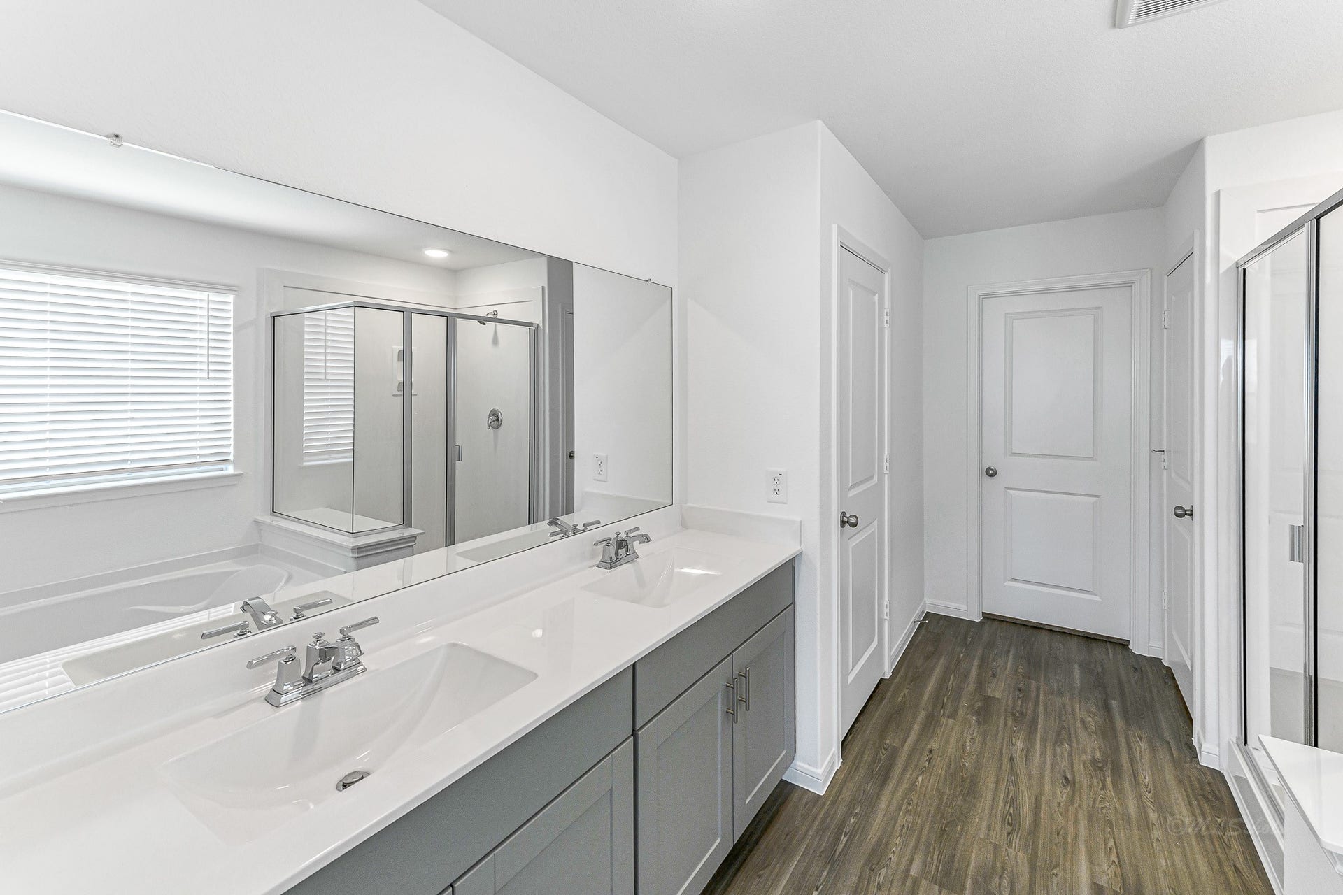 Primary Bathroom with double vanities, spacious shower, tub, natural light, private WC, walk-in closet and linen closet.