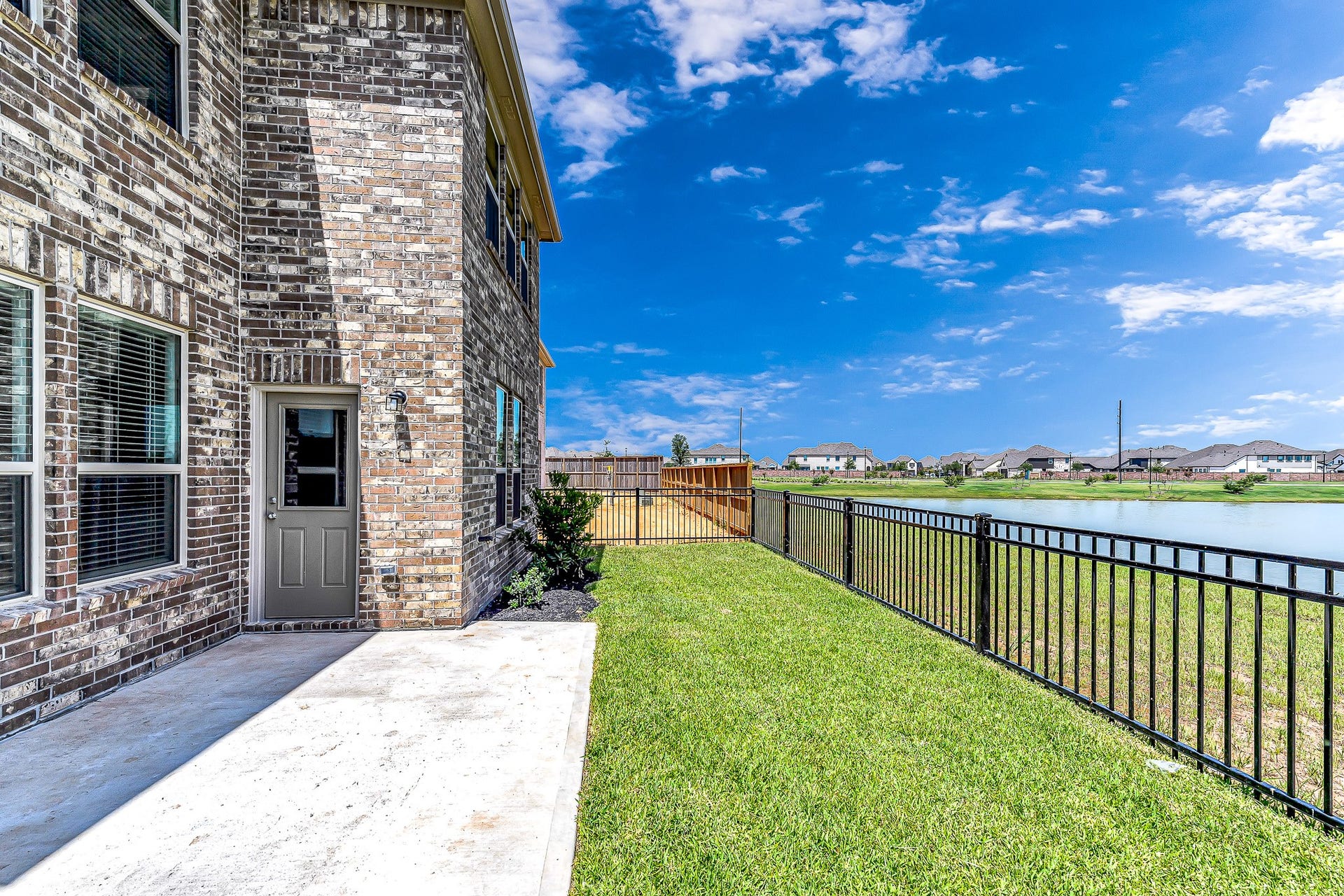 Oasis backyard with extended concrete deck and a stunning view to the green belt and lake.