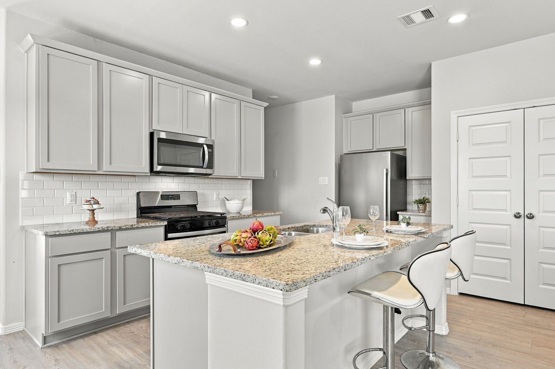 5702 Fresh View Court, Katy, TX 77493 Beautifully appointed with granite countertops, classic white subway tile backsplash, abundant shaker-style cabinetry, & stainless steel appliances, this kitchen offers an exceptional combination of style & functionality. The oversized center island provides generous workspace, while recessed lighting & a spacious pantry add everyday convenience.