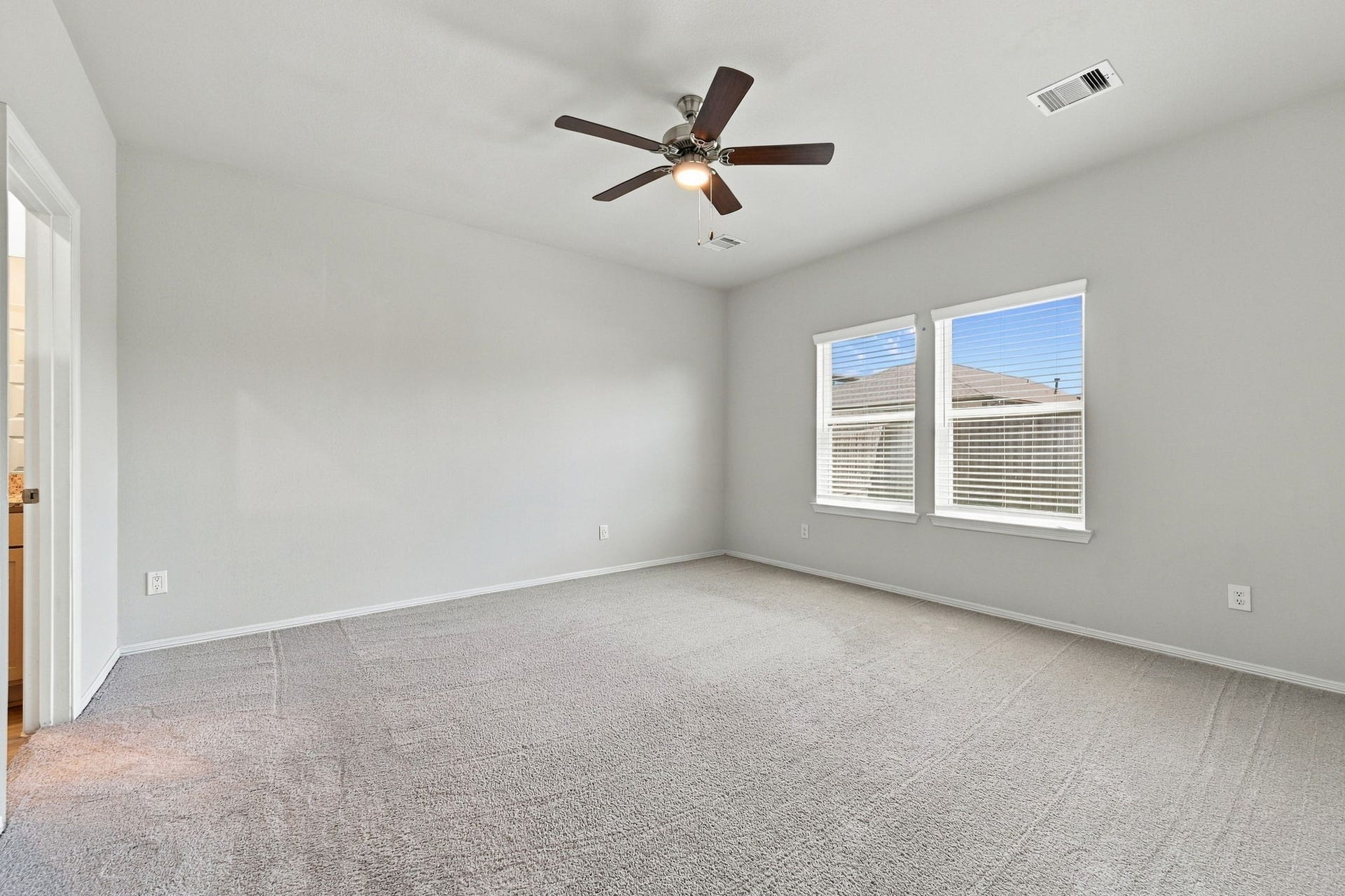 5702 Fresh View Court, Katy, TX 77493 The spacious primary bedroom offers a wonderful combination of privacy, comfort, & flexibility. Large windows brighten the interior, while high ceilings, neutral carpeting, & a stylish ceiling fan provide an inviting backdrop for creating your own personal retreat.