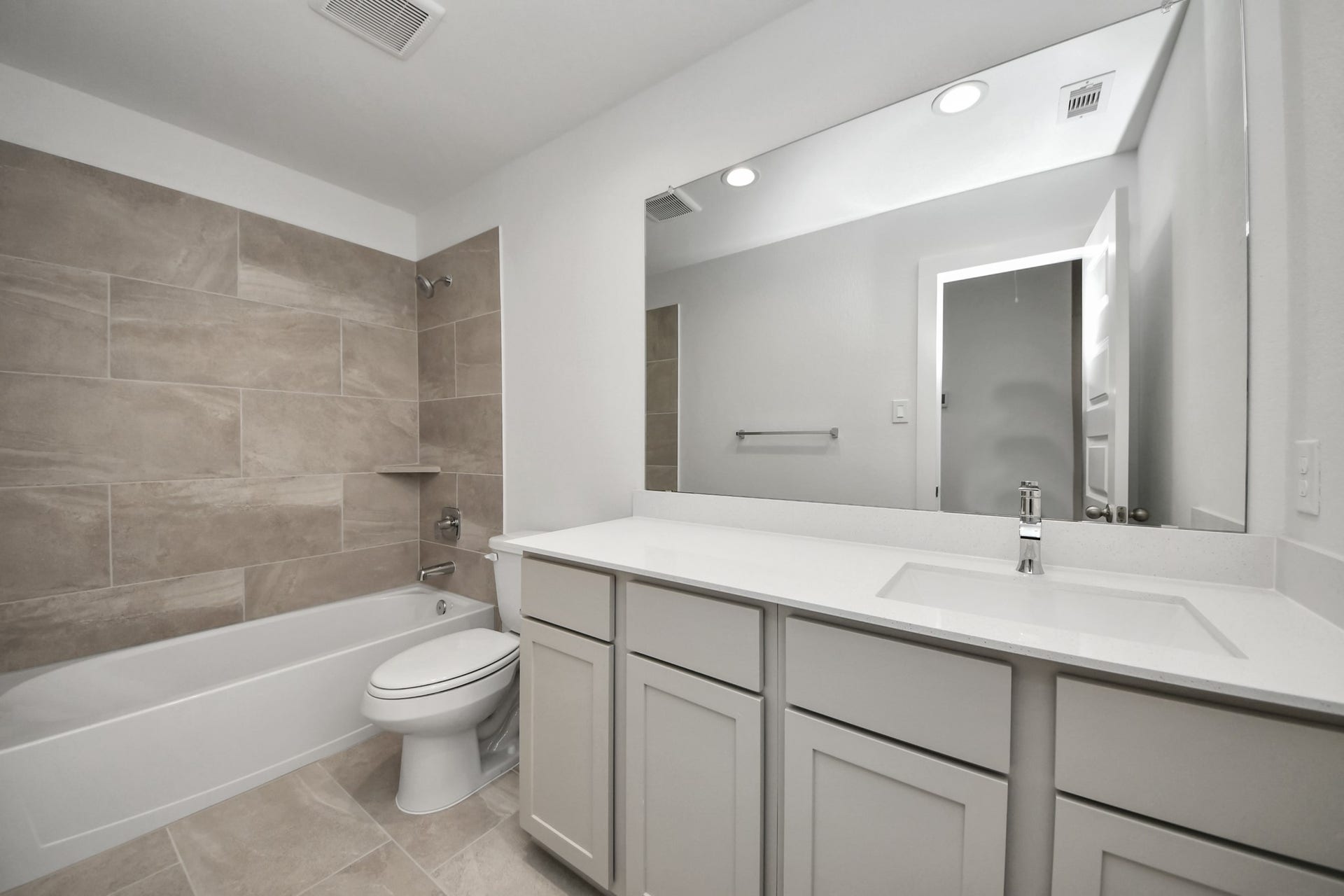 26395 Viva Drive, Magnolia, TX 77355 Secondary bath features tile flooring, bath/shower combo with tile surround, light stained wood cabinets, beautiful light countertop. Sample photo of completed home with similar floor plan. Actual colors and selections may vary.