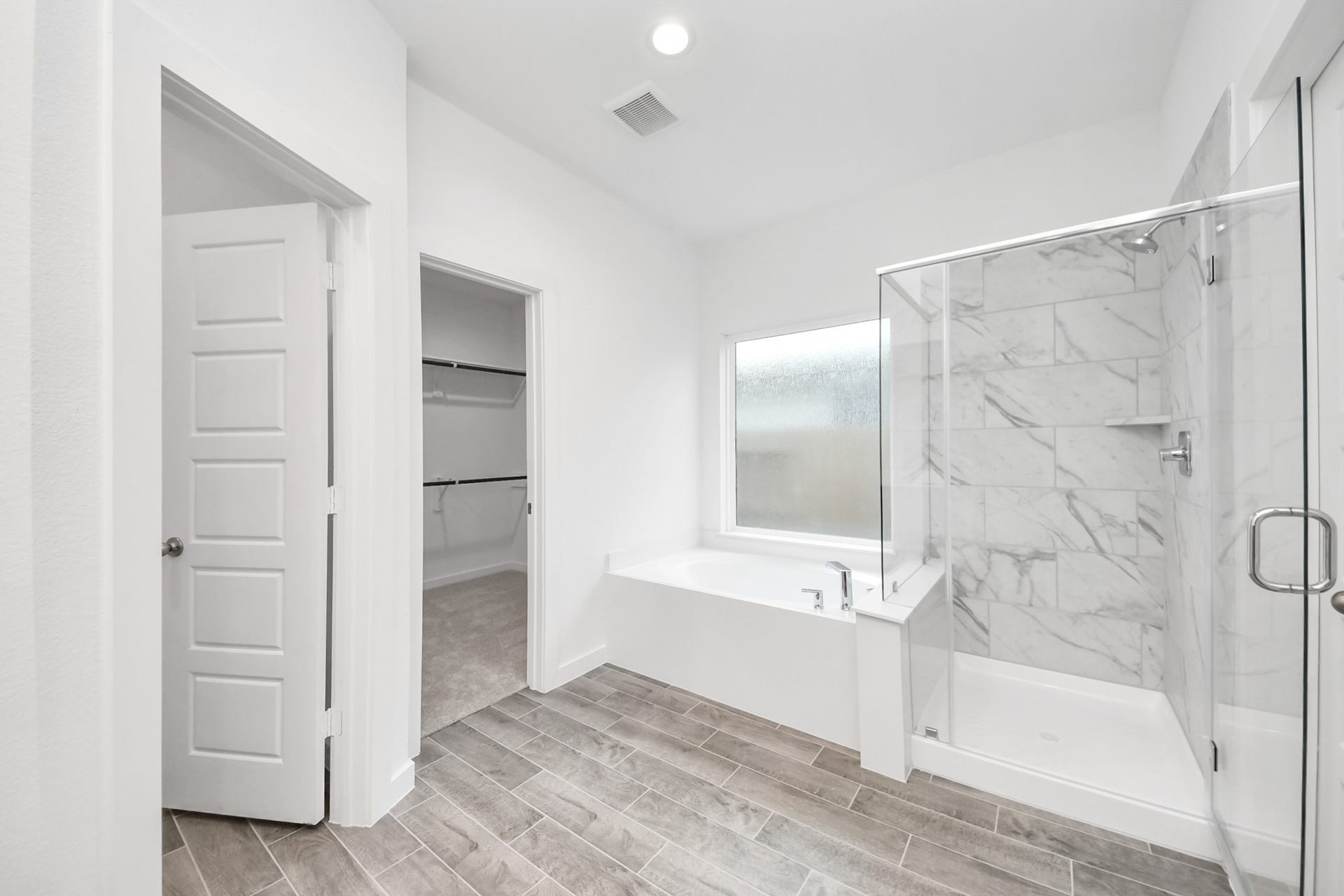 26395 Viva Drive, Magnolia, TX 77355 Indulge in a spa-like retreat within the confines of this primary bathroom. Delight in a spacious walk-in shower enveloped in stylish tile surround, unwind in a separate garden tub adorned with custom detailing.