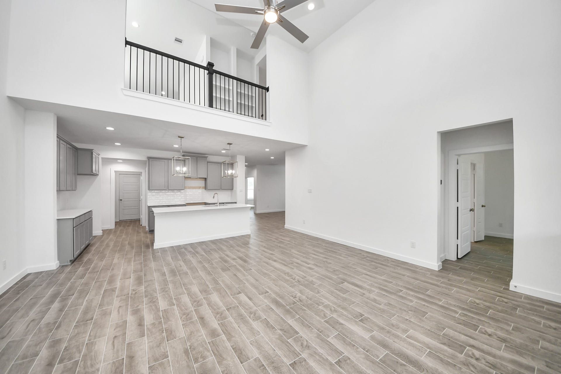 26395 Viva Drive, Magnolia, TX 77355 Family room flooded with natural light through the expansive windows. The premium tile flooring adds a touch of luxury to the space, creating the perfect setting for relaxing moments and cherished gatherings with loved ones