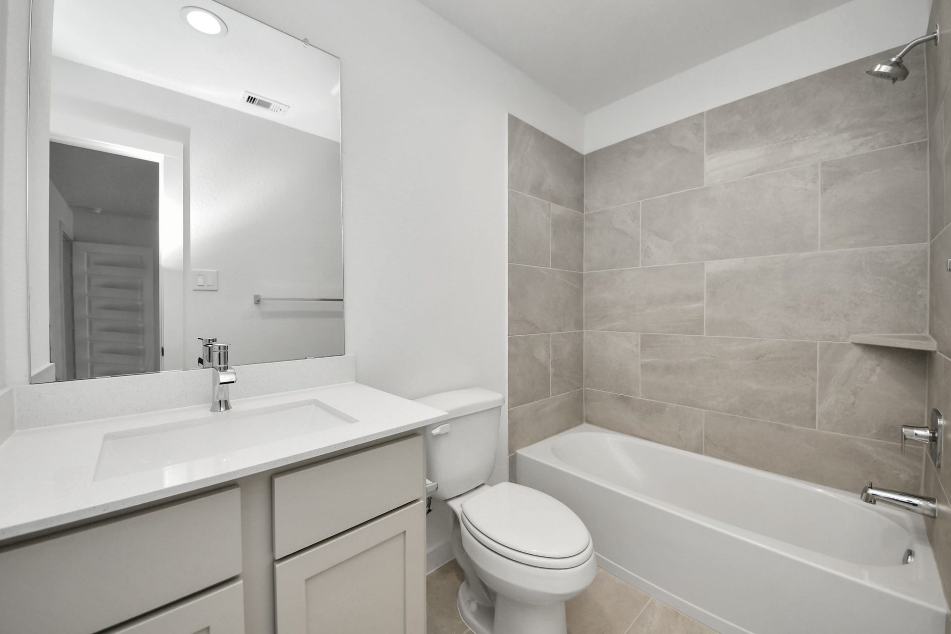 26395 Viva Drive, Magnolia, TX 77355 Secondary bath features tile flooring, bath/shower combo with tile surround, light stained wood cabinets, beautiful light countertop. Sample photo of completed home with similar floor plan. Actual colors and selections may vary.