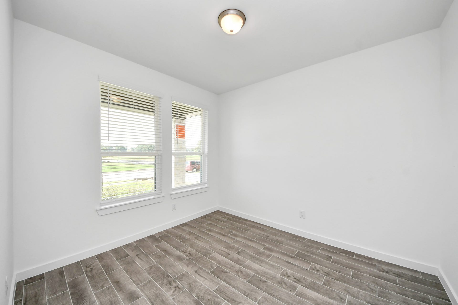 26395 Viva Drive, Magnolia, TX 77355 Experience the perfect blend of sophistication and warmth in this home office, boasting elegant wood-look tile flooring and flooded with natural light from expansive windows and French doors.