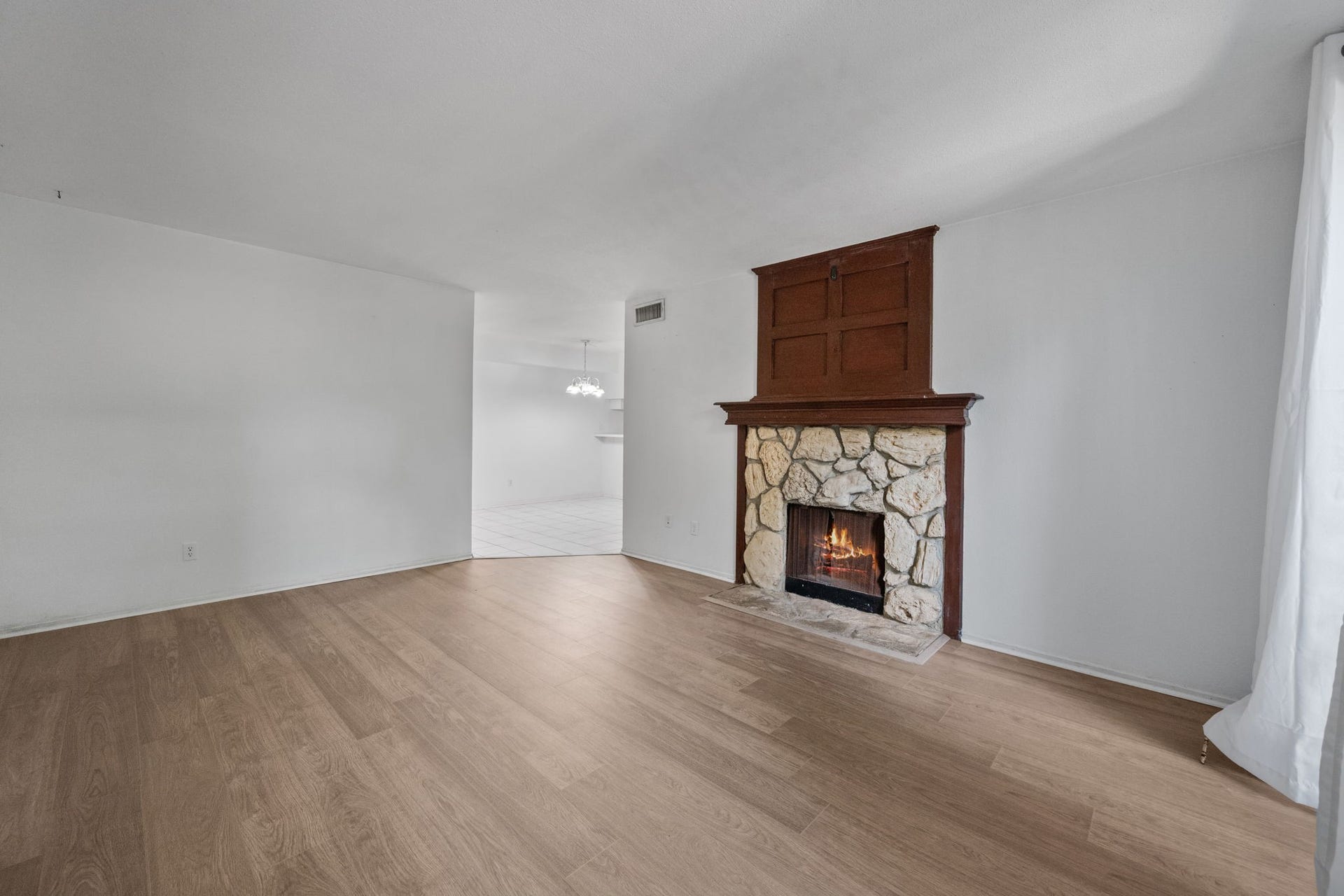 4649 Wild Indigo Street, #337, Houston, TX 77027 Spacious living area featuring a cozy stone fireplace, complemented by elegant wood flooring and abundant natural light.