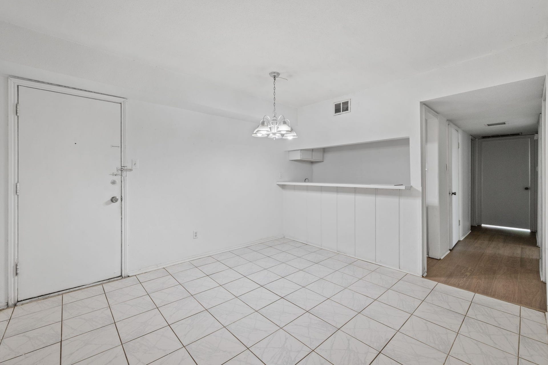 4649 Wild Indigo Street, #337, Houston, TX 77027 Bright and airy space with tiled floors and a cozy dining area, featuring a pendant light fixture and a convenient pass-through to the kitchen.